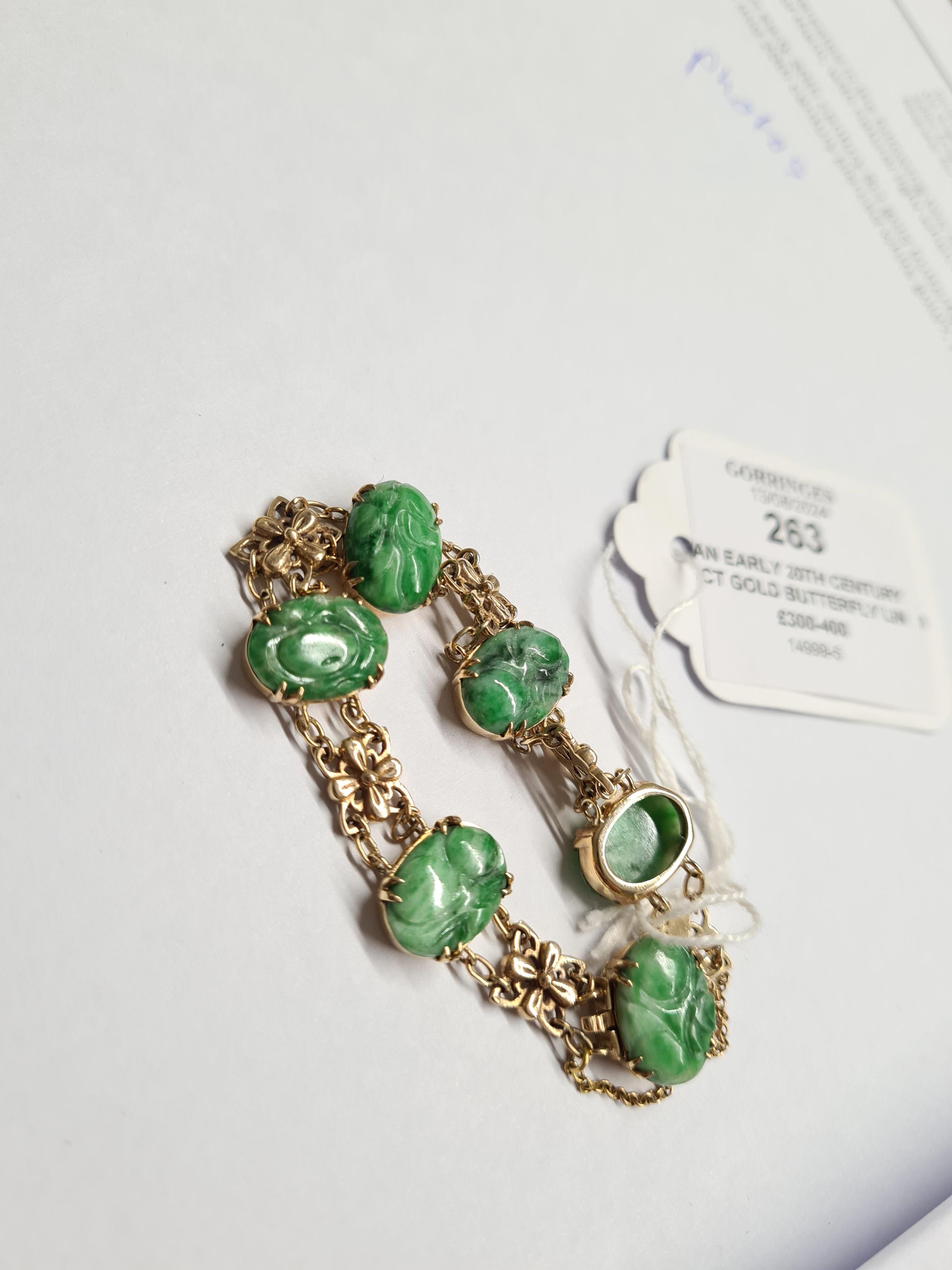 An early 20th century 9ct gold butterfly link and six stone carved jade set bracelet